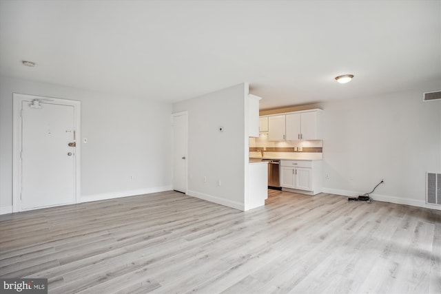 unfurnished living room with sink and light hardwood / wood-style flooring