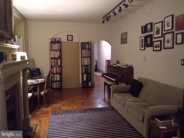 living area with arched walkways and track lighting