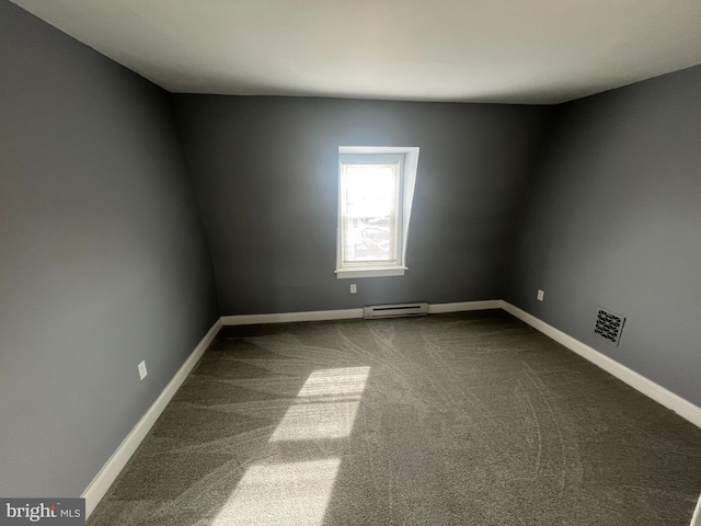 carpeted empty room with a baseboard heating unit