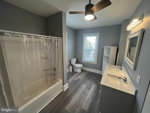 full bathroom featuring wood-type flooring, vanity, ceiling fan, toilet, and shower / bath combo with shower curtain