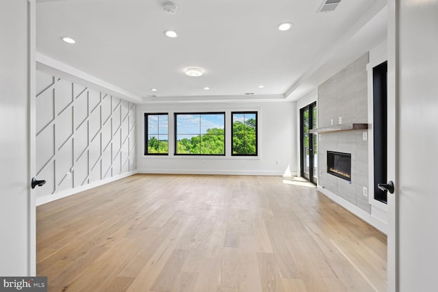 unfurnished living room featuring a tile fireplace, visible vents, light wood-style flooring, and recessed lighting