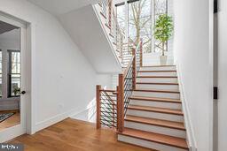 stairway featuring lofted ceiling, wood finished floors, and baseboards