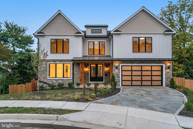 view of front of property featuring a garage, metal roof, a standing seam roof, fence, and decorative driveway