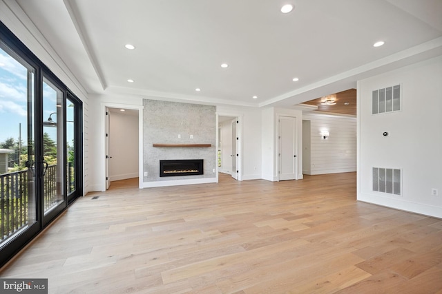 unfurnished living room featuring light wood-type flooring, a fireplace, and visible vents