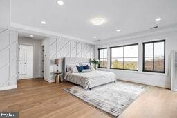 bedroom with ornamental molding, wood finished floors, and recessed lighting