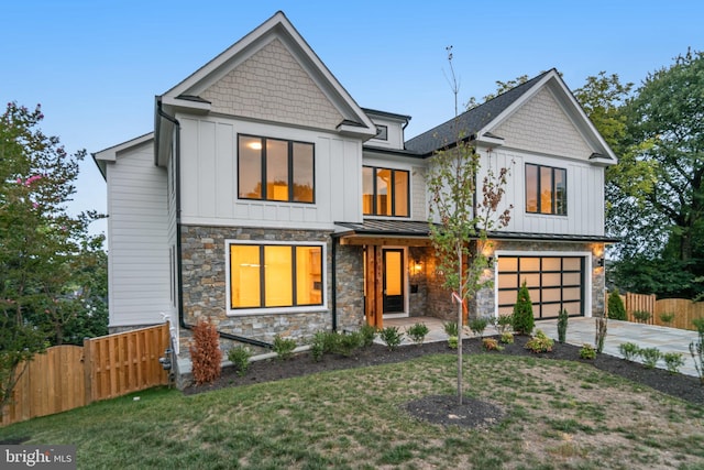 view of front facade featuring a garage, driveway, a standing seam roof, fence, and board and batten siding