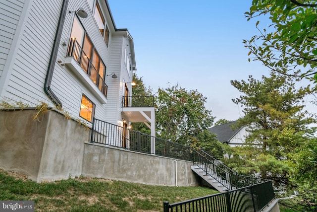 view of home's exterior with stairway and fence