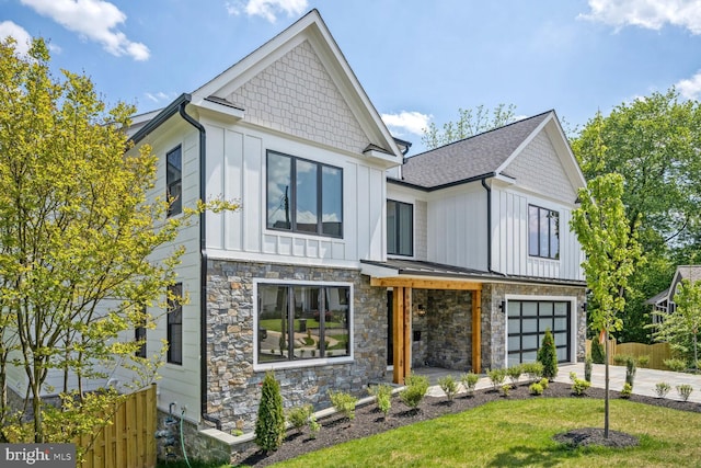 view of front facade with board and batten siding, concrete driveway, a front lawn, and an attached garage