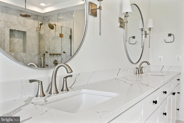 full bath with a sink, a shower stall, and double vanity