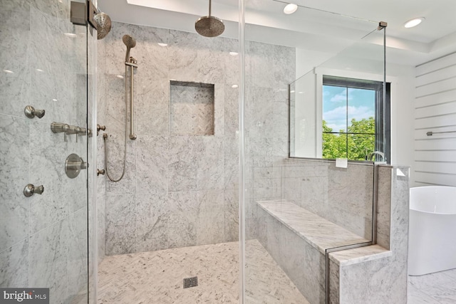 full bathroom featuring a freestanding bath and a shower stall