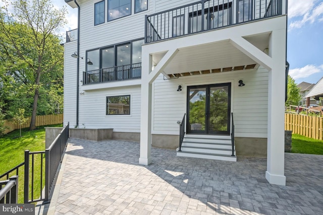 exterior space featuring entry steps, a balcony, a patio area, and fence