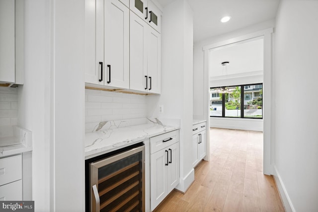 bar with beverage cooler, baseboards, decorative backsplash, light wood-type flooring, and recessed lighting