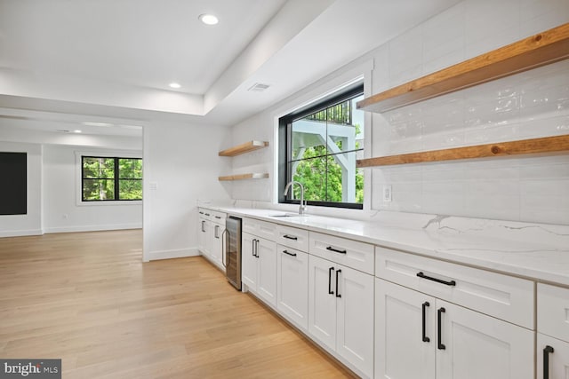 kitchen with light stone counters, beverage cooler, white cabinetry, light wood-style floors, and open shelves