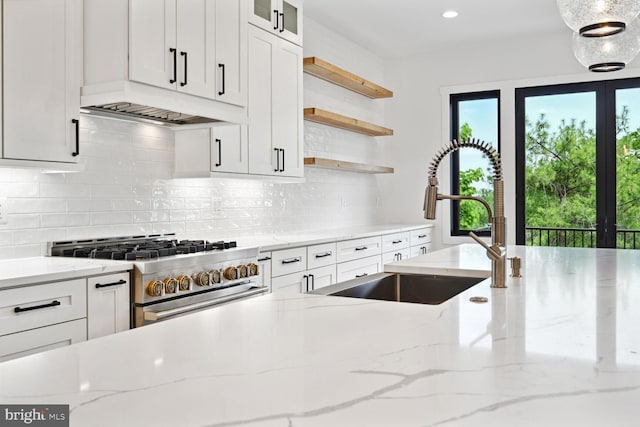 kitchen with open shelves, high end stainless steel range oven, and light stone countertops