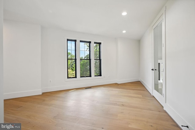 unfurnished room featuring light wood-type flooring, visible vents, baseboards, and recessed lighting