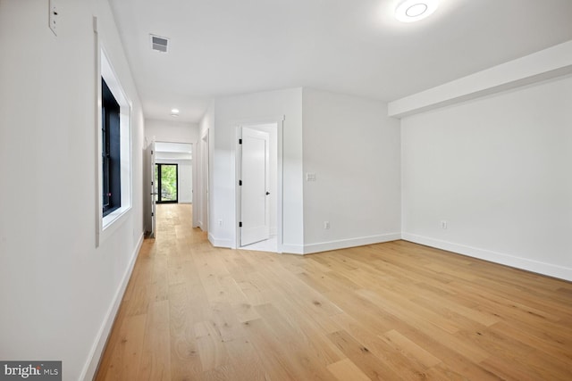 interior space with light wood finished floors, visible vents, and baseboards