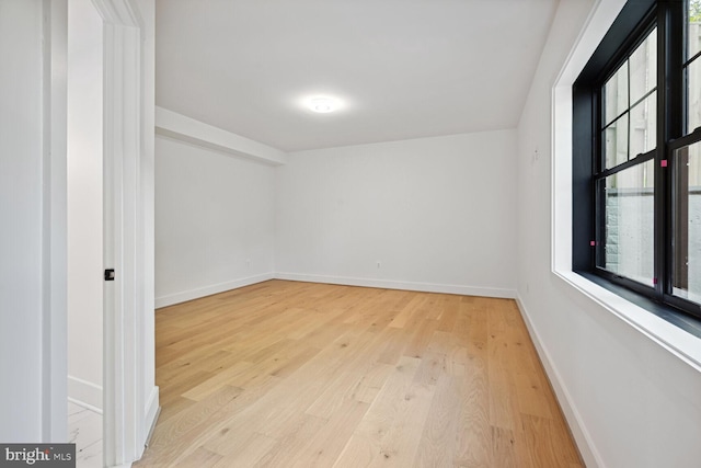 unfurnished room with light wood finished floors and baseboards