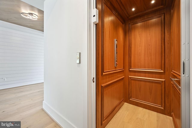 room details with baseboards, wood finished floors, and elevator