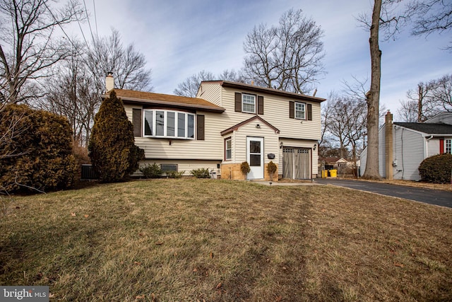 view of front of property featuring a garage and a front lawn