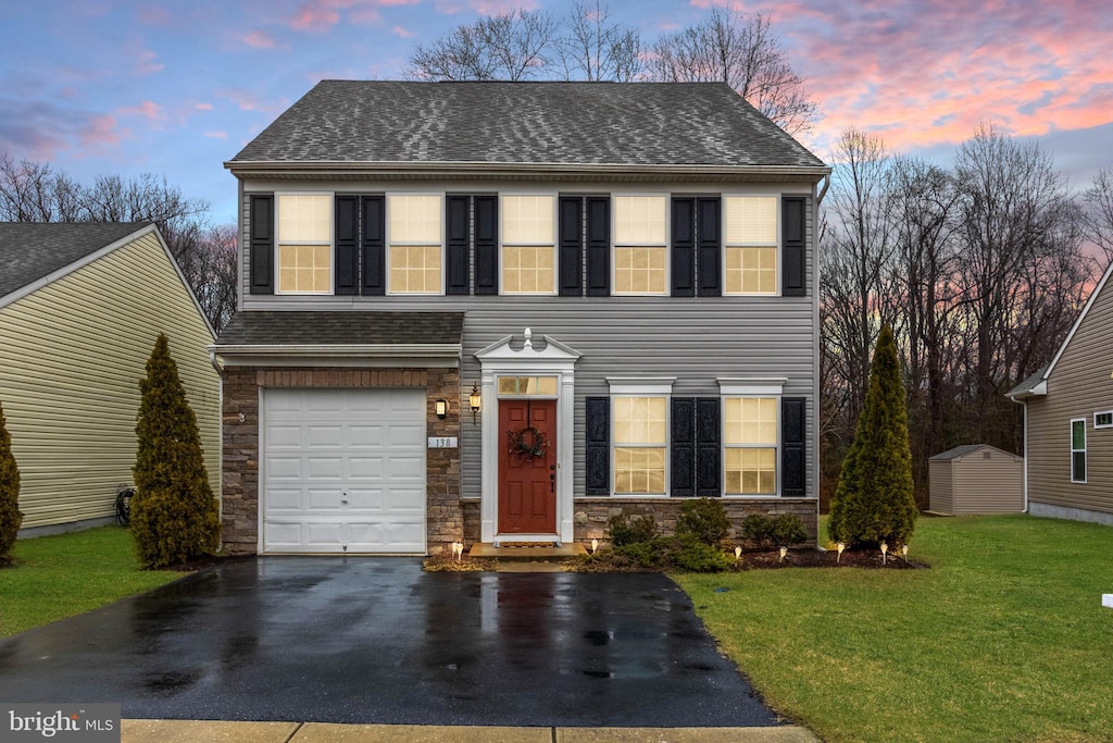 view of front of house featuring a garage and a lawn