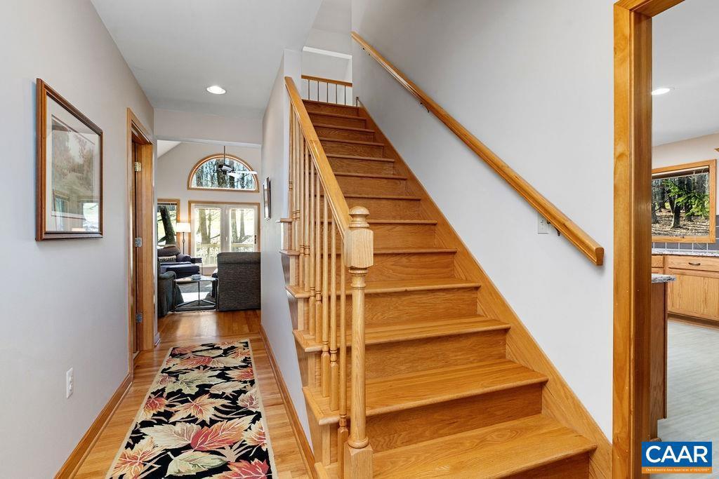 stairs with hardwood / wood-style floors and a wealth of natural light