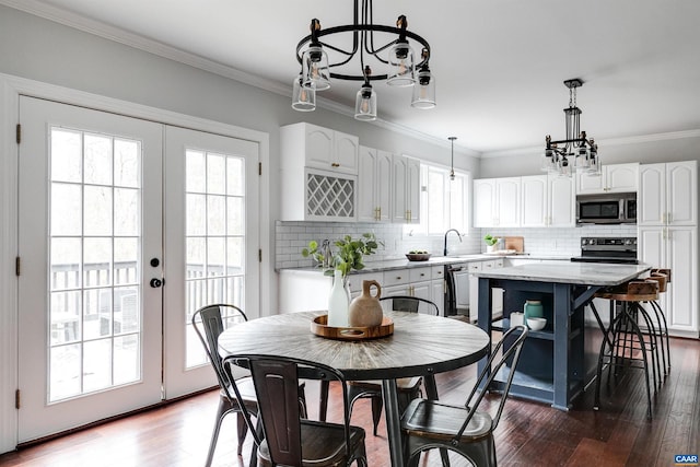 dining room with ornamental molding, sink, dark hardwood / wood-style flooring, and french doors