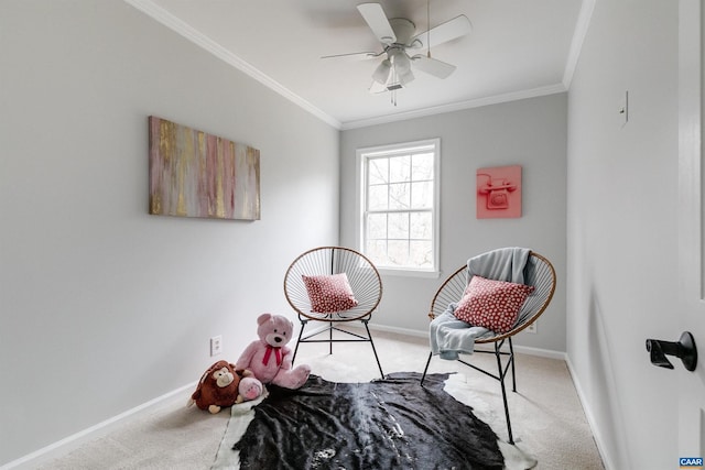 sitting room with ceiling fan, ornamental molding, and light carpet