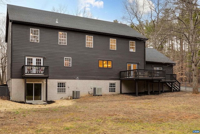 back of house with central AC unit, a lawn, and a wooden deck