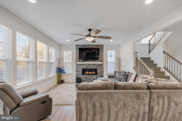 living room with wood finished floors, recessed lighting, stairway, a fireplace, and baseboards