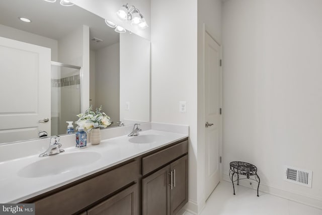 bathroom with a sink, visible vents, an enclosed shower, and double vanity