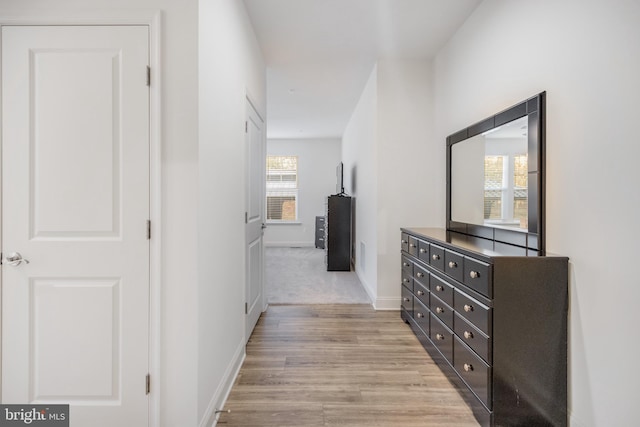 hallway featuring light wood-type flooring and baseboards