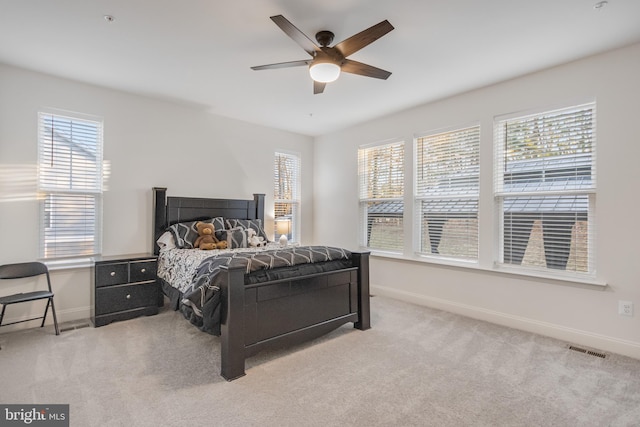 carpeted bedroom with visible vents, baseboards, and a ceiling fan