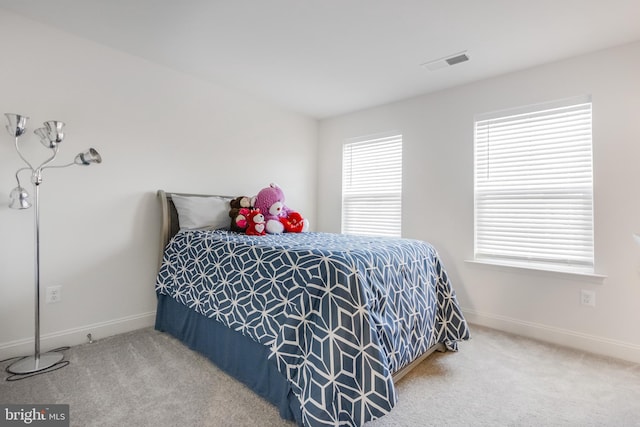 carpeted bedroom with visible vents and baseboards