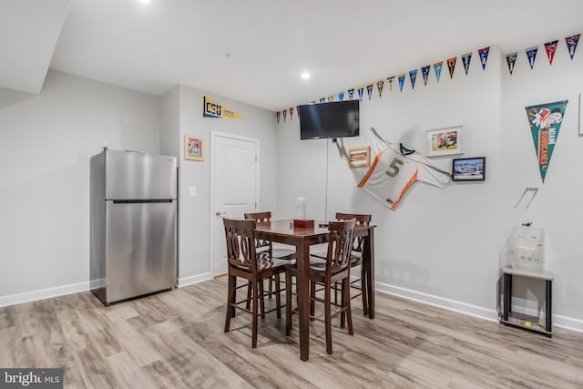 dining space with recessed lighting, baseboards, and light wood-type flooring