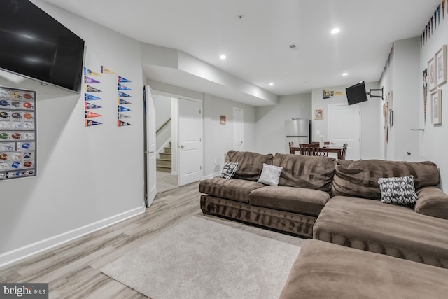 living area with recessed lighting, stairway, baseboards, and light wood-style floors