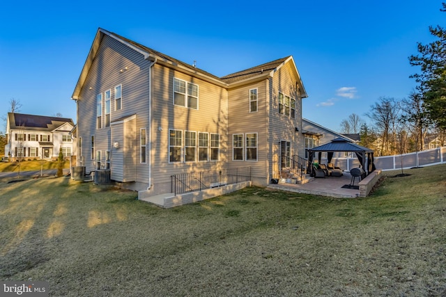 back of house featuring a patio, fence, a gazebo, central air condition unit, and a lawn