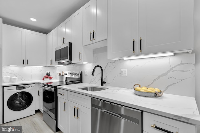 kitchen featuring sink, washer / dryer, white cabinets, and appliances with stainless steel finishes