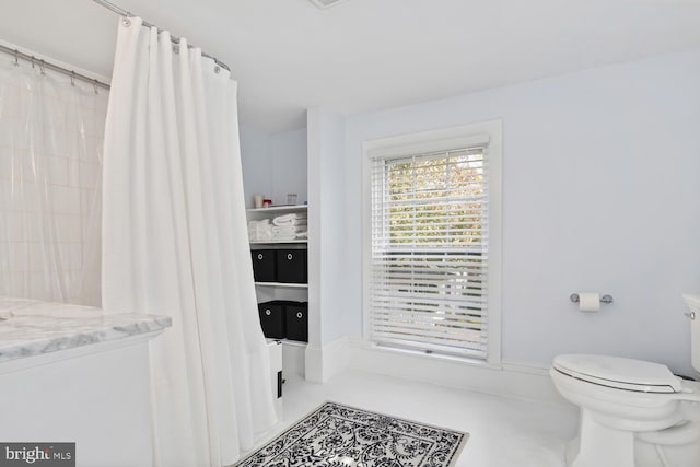 bathroom with toilet and tile patterned flooring