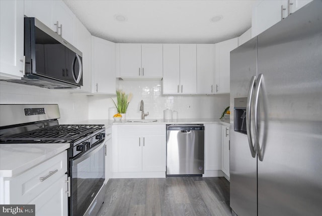 kitchen featuring dark wood-type flooring, stainless steel appliances, sink, and white cabinets