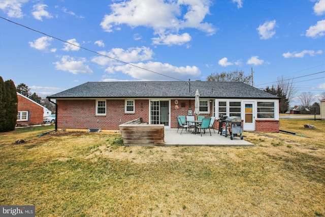 rear view of house with a patio and a lawn