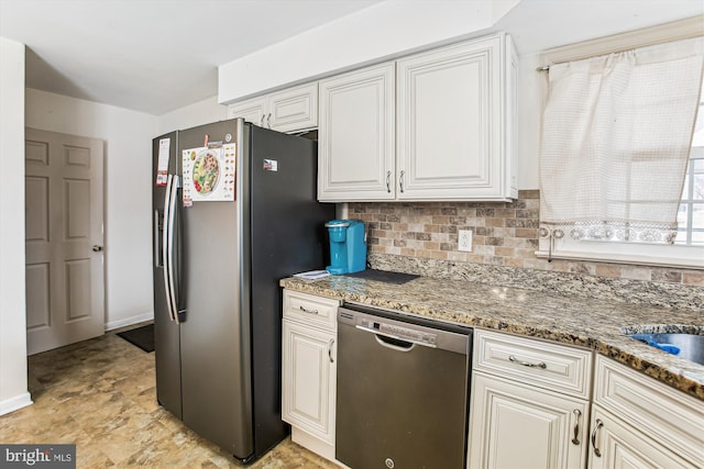 kitchen featuring white cabinetry, appliances with stainless steel finishes, tasteful backsplash, and dark stone counters