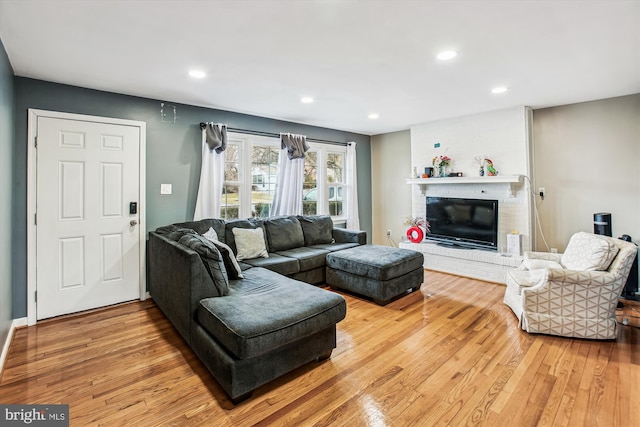 living room featuring hardwood / wood-style floors and a brick fireplace