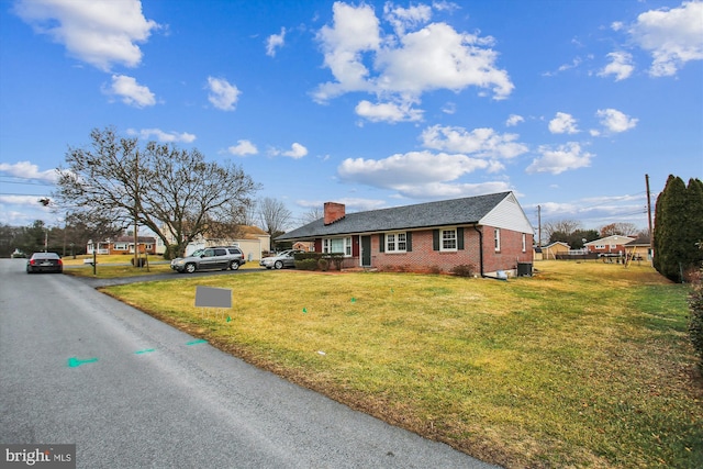 view of front of house with central AC and a front lawn