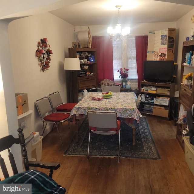 dining area featuring dark hardwood / wood-style floors and a chandelier