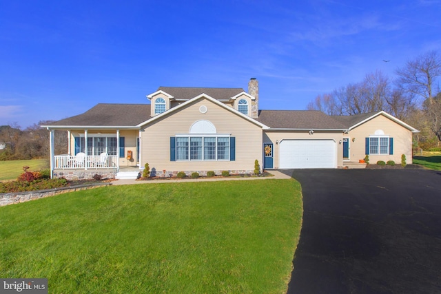 view of front of house with a garage, a front lawn, and a porch