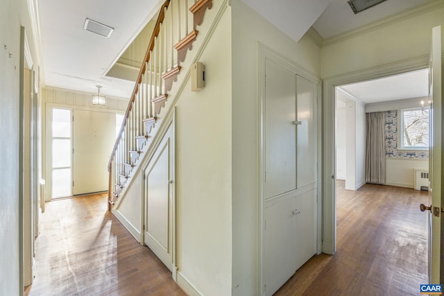 hall with hardwood / wood-style flooring, ornamental molding, and radiator heating unit