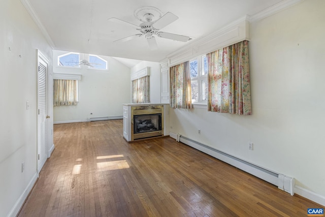 unfurnished living room featuring a baseboard radiator, hardwood / wood-style floors, and a wealth of natural light