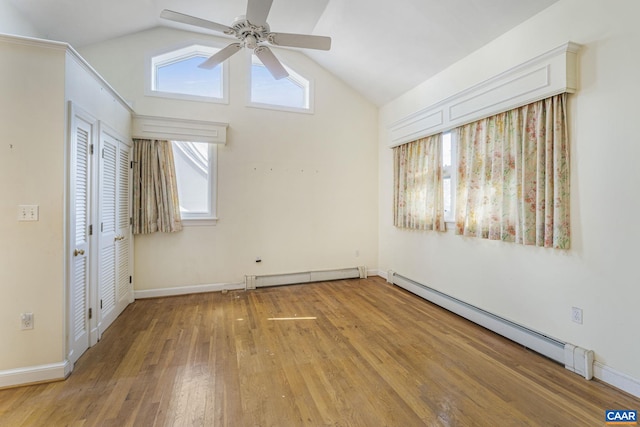 interior space with lofted ceiling, hardwood / wood-style floors, and baseboard heating