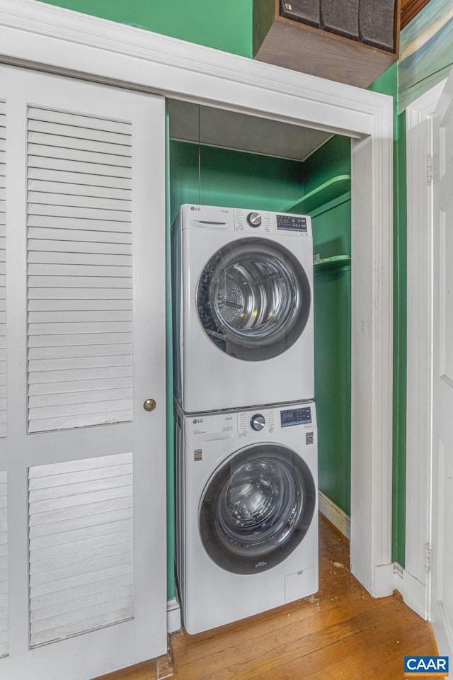 washroom featuring stacked washing maching and dryer and hardwood / wood-style floors