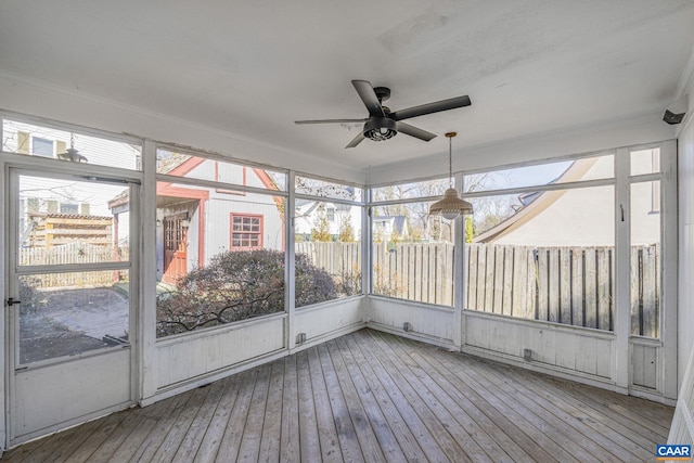 unfurnished sunroom featuring ceiling fan